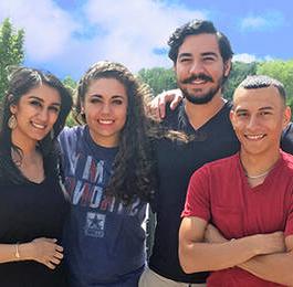 Students smiling and happy with sky in the background